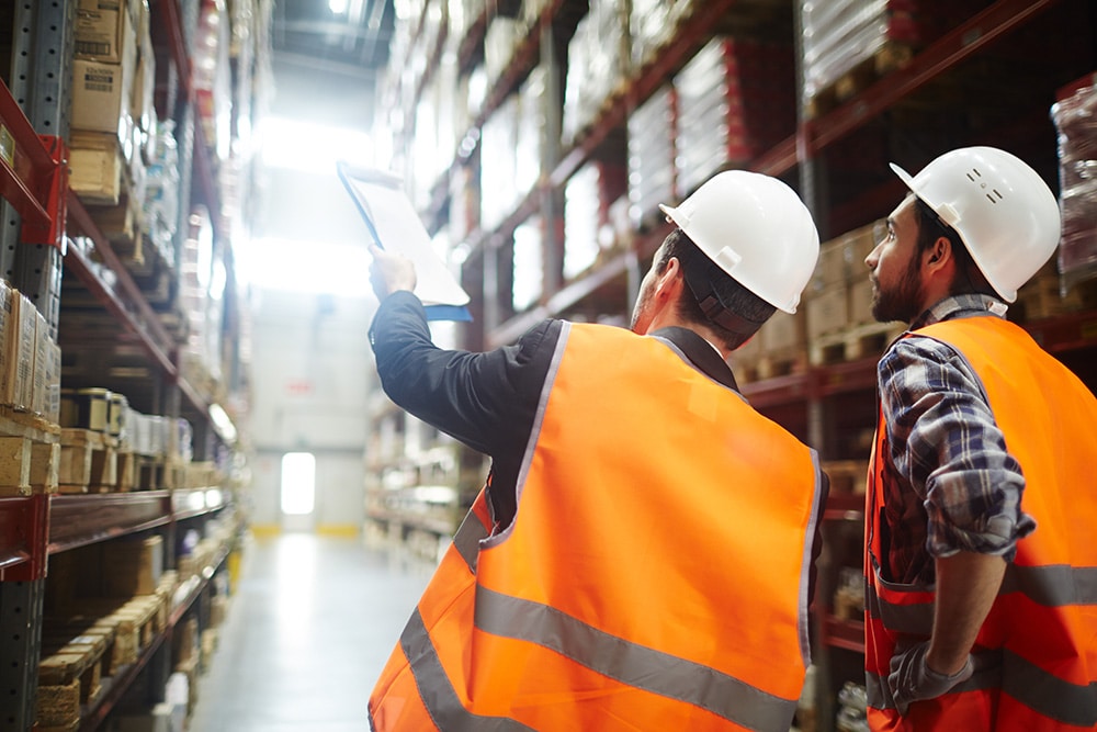 LED Audit managers discussing amount of loaded goods in racks