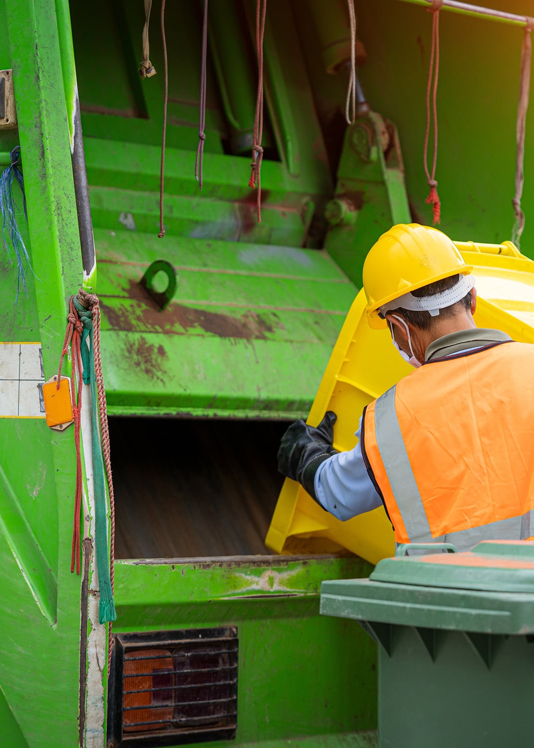 Image of rubbish truck with workers tipping bin inside